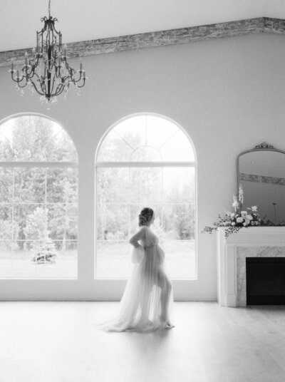 Expectant mother in stunning tulle dress backlit by window in gorgeous Edmonton venue