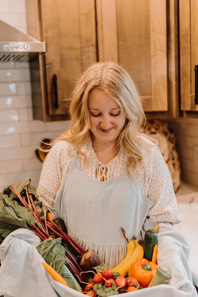 Kenna holding fresh whole foods used to support fertility and family health.