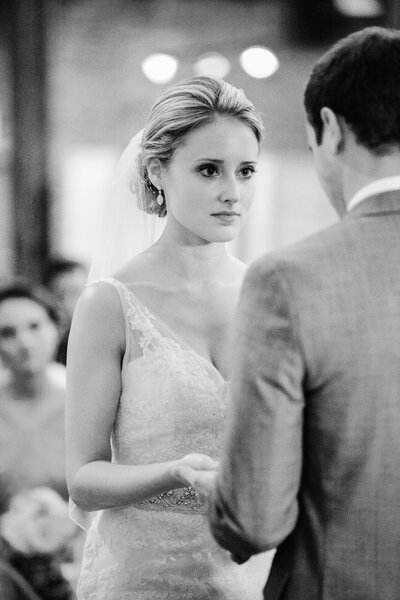 A dramatic and elegant first look moment on a Chicago rooftop, featuring a bride in a Naeem Khan wedding dress with the city skyline behind her.