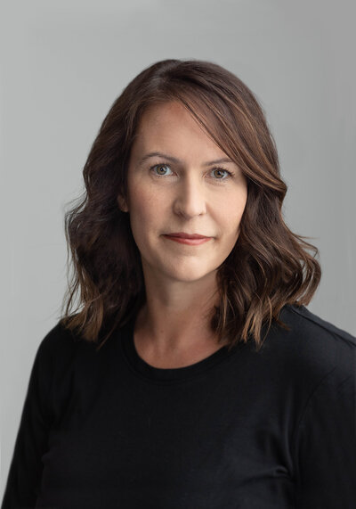Headshot of a woman with dark hair against a gray backdrop