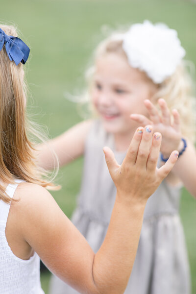 sweet detail of hands while two little girls playing together