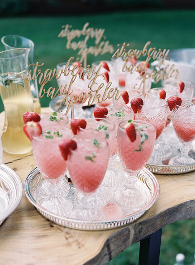 Cocktail stir sticks in bright pink tray-passed cocktails featuring handwritten script style