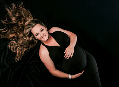 An overhead maternity pose, beautiful black maternity gown.