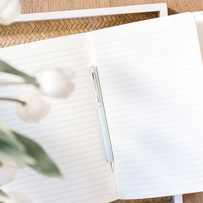 notebook with pen and white flowers