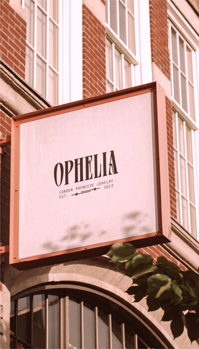 mockup of a shop sign outside an urban brick building with the ophelia logo