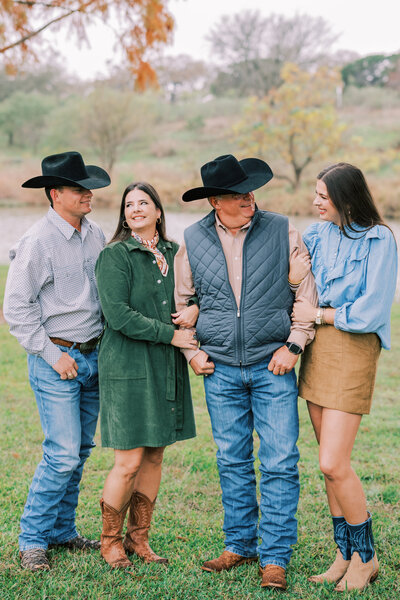 Family of four looking at each other and smiling