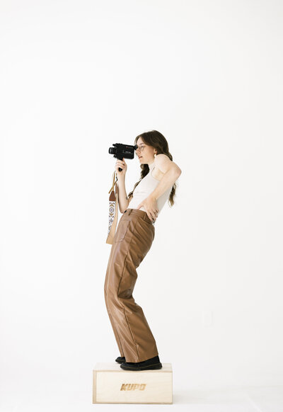 videographer with camera stands on wood block