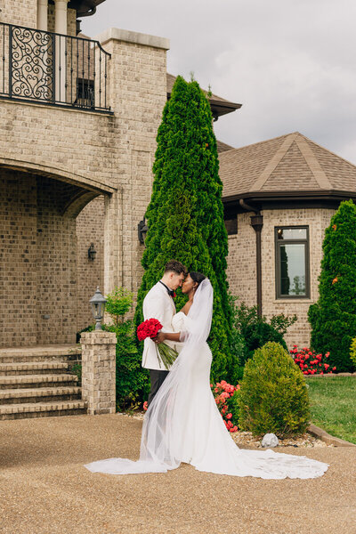 Bride and groom touching foreheads in front of Naimoli Estate, a wedding venue in Hopkinsville, KY.
