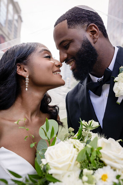 black bride and groom nose to nose on their wedding day