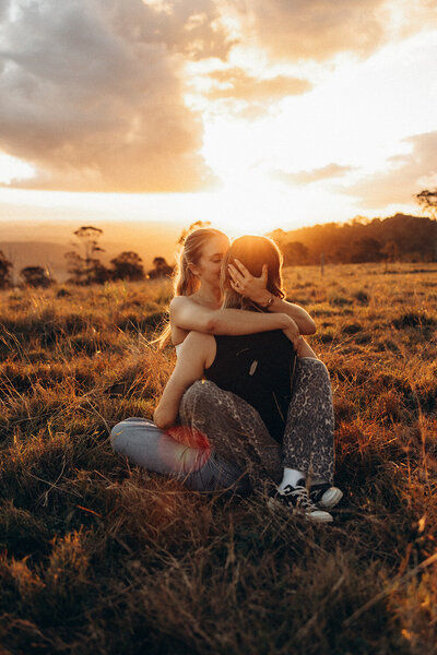 emotive golden hour portrait of two women cuddling during a surprise engagement session. LGBTQIA+ photographer sunshine coast