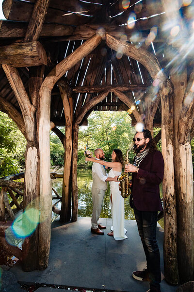 Couple enjoying their time at Jane's Carousel during their engagement session.  The male is in a light blue greyish suit and the female has a high-low dress.