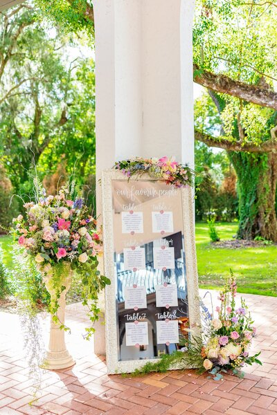 Mirror with photos and flowers at an outdoor wedding ceremony