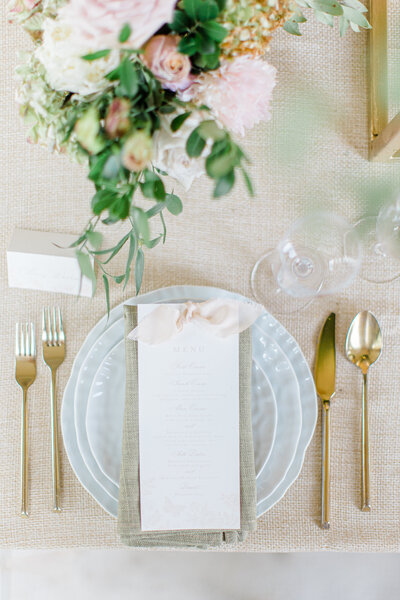 Wedding reception table setting with menu and floral centerpiece