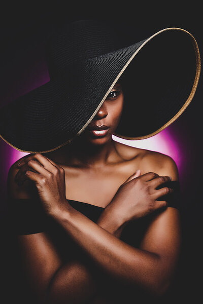 Woman of color in big black hat