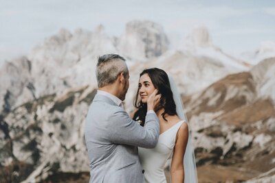 A couple stands on a rock facing each other in Tre Cime national park during their elopement day