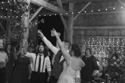 the bride and groom cheers to their guests on the dance floor at their wisconsin wedding