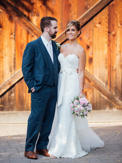 The Inn at Barley Sheaf Farm | Bride and groom posing with barn in background during wedding photo | Holicong, Pennsylvania