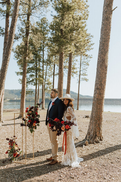 bride and groom standing in a forest