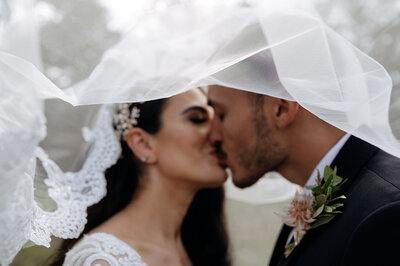 couple kissing under veil