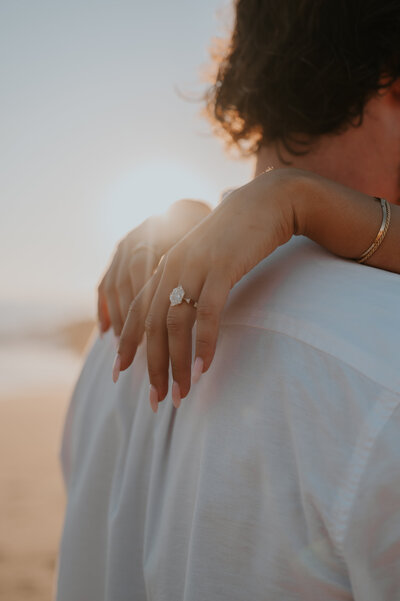 a couple recently engaged after a proposal on the beach in california