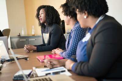 Professional women engaged in a focused discussion during a team meeting