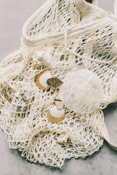 a net looking beach bag with shells