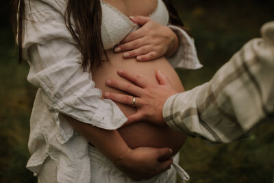 maternity photo with father's hand on baby bump