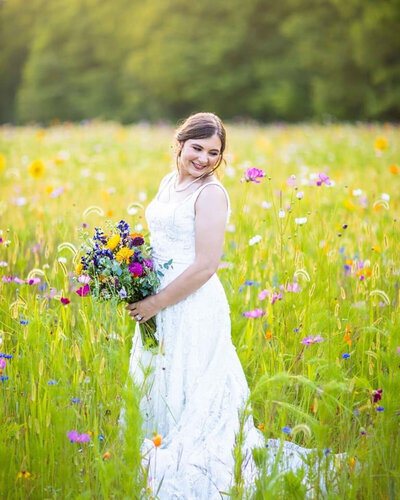 Bride standing in a colorful wildflower field holding bouquet