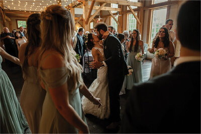 married couple kissing in front of the bridal party