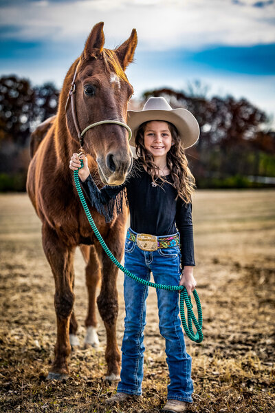 Girl at rodeo next to Sorrel Horse