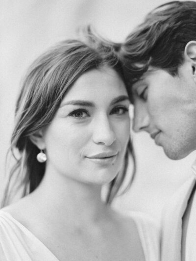 black and white photo of a bride and groom touching foreheads