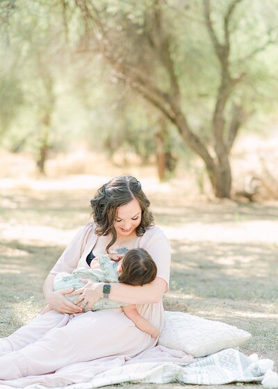 Parents holding six month baby while cuddled together in studio milestone session