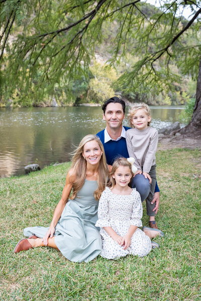 family of four posting by the river