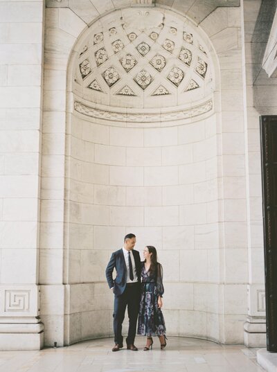 couple embraced under the arch at the NYC Public Library