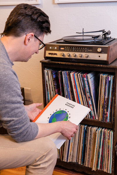 man looking at his collecting of vinyl records during personal branding photo shot with laure photography
