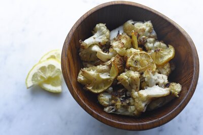 Bowl of thinly sliced lemons and cauliflower 