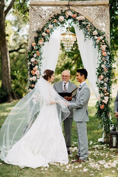 Hill country wedding ceremony with floral arch