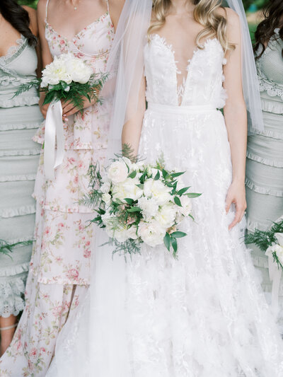Detail shot of the bride and her bridesmaids. You can see the texture of the dresses and their flowers in their hands.