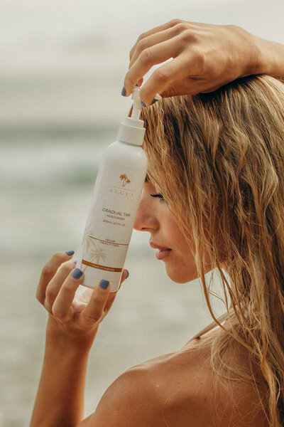 Sunshine Coast commercial photography of skincare product standing on the beach.
