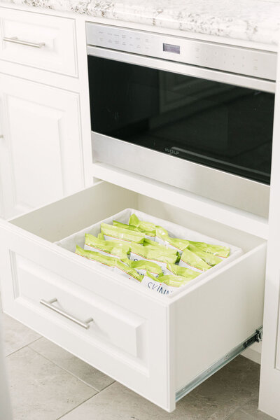 Pantry snacks organized in a basket in kitchen drawer