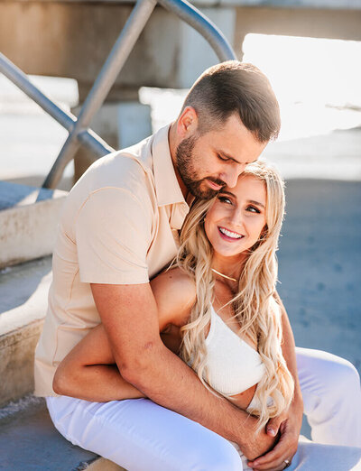 A man and woman snuggle on the beach in Tampa, Florida during their Elopement Photos.
