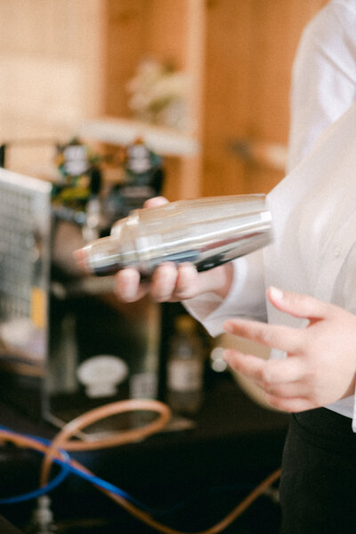 A bartender making a drink in an image captured by wedding photographer Hannika Gabrielsson.