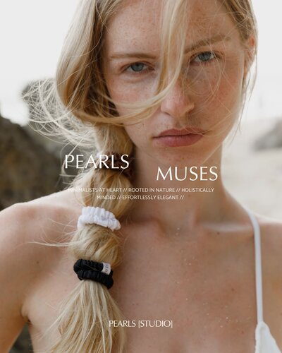 A woman with windblown hair, wearing a white top with a braided hairstyle, overlaid with text that reads 'PEARLS MUSES' and brand descriptors like 'Holistically Minded' and 'Effortlessly Elegant'.