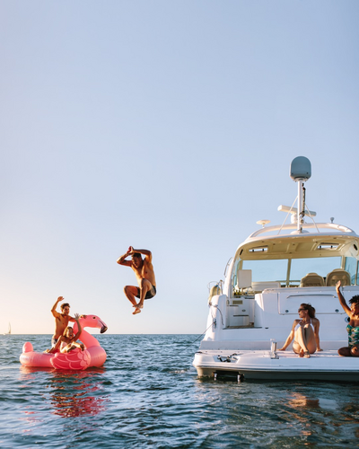 A man jumps off a private yacht into the ocean