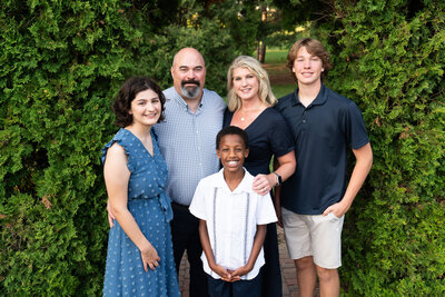 Family of four laughing together during their family photos