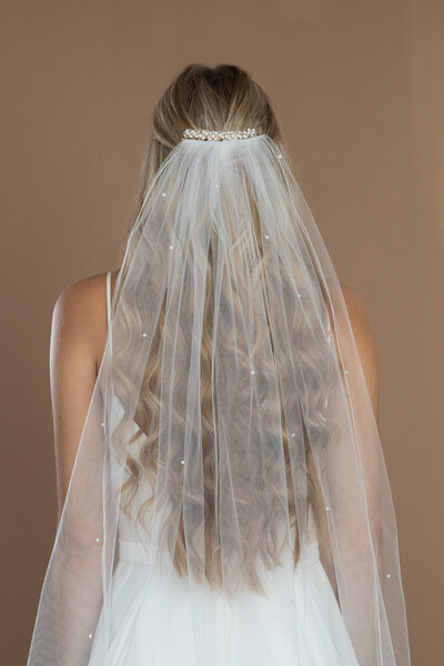 bride wearing a pearl veil and hair comb with pearls and crystals