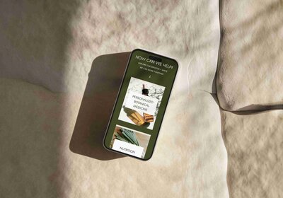 A smartphone rests on a stone surface, with a book beside it, reflecting a calm, naturopathic vibe.