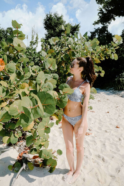 picture of girl in bikini standing near tropical caribbean plant by traveling portrait photographer