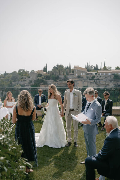 Black and white photo of a Bastide de Gordes wedding dinner featuring a long, rectangular table, soft candlelight and medieval architecture
