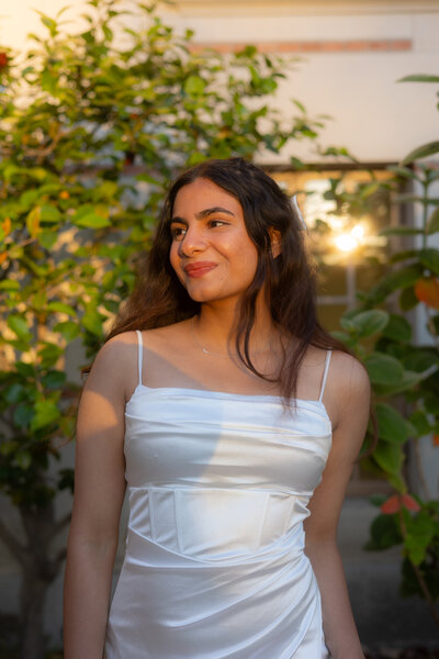 Woman wearing a satin white dress in golden hour